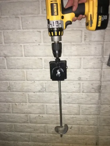 Cordless drill with an anchor adapter and helix ground anchor attached